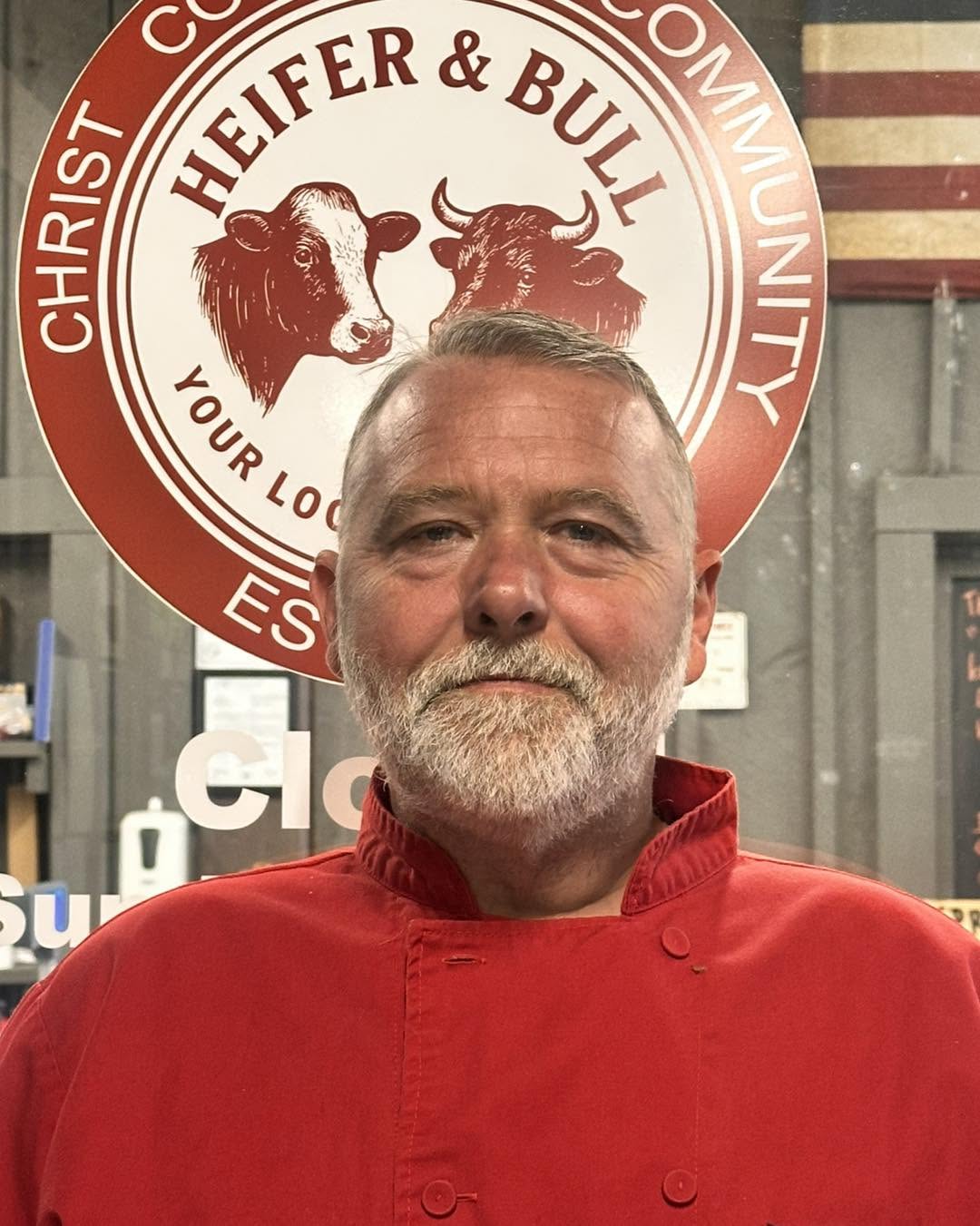 Ryan Lee Raney at the shop counter, in his red chef's coat